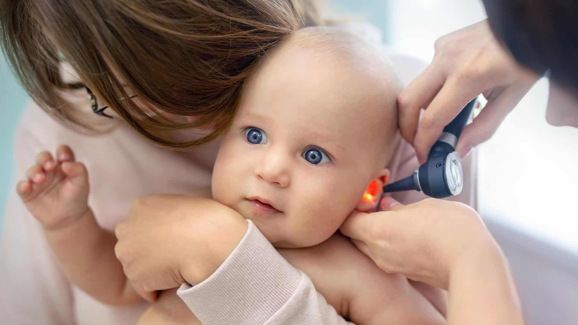 Um bebê em consulta médica checando o ouvido