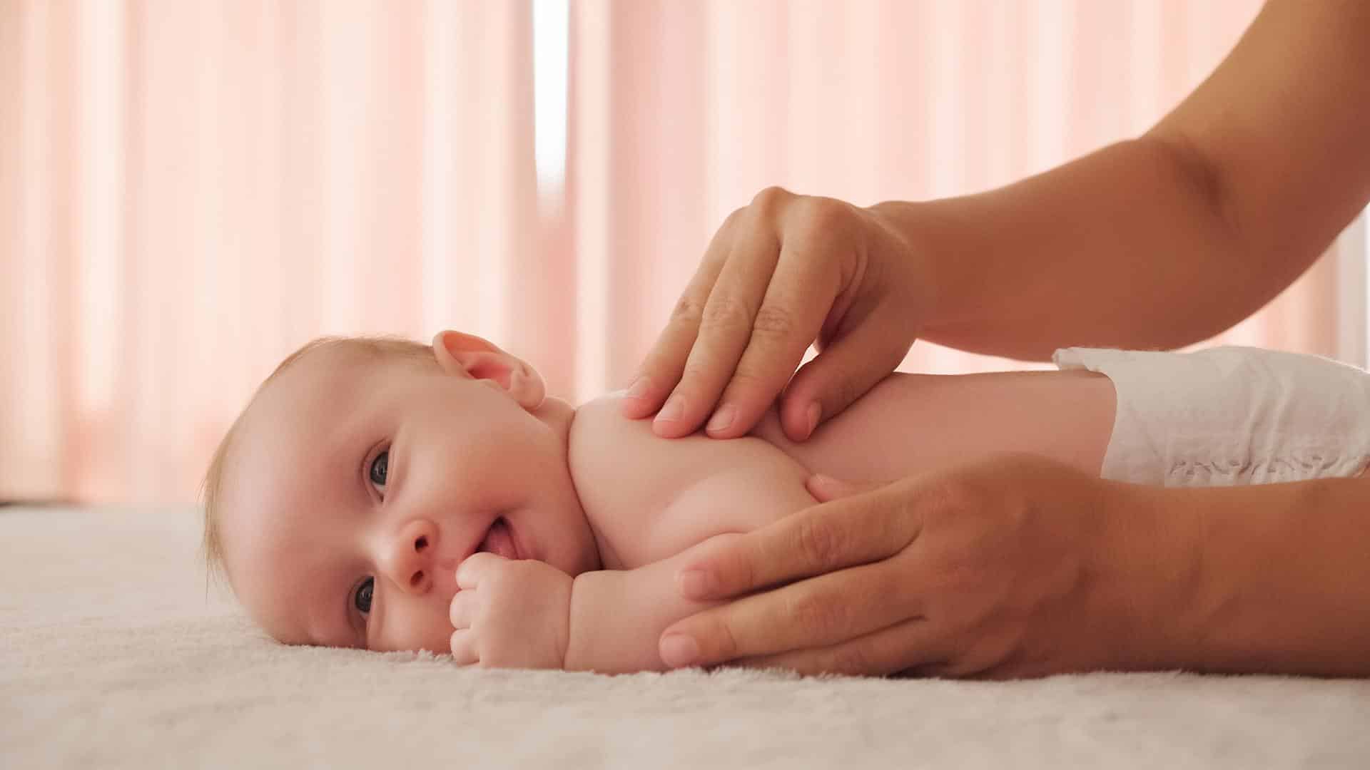 Mãe fazendo massagem suave no filho