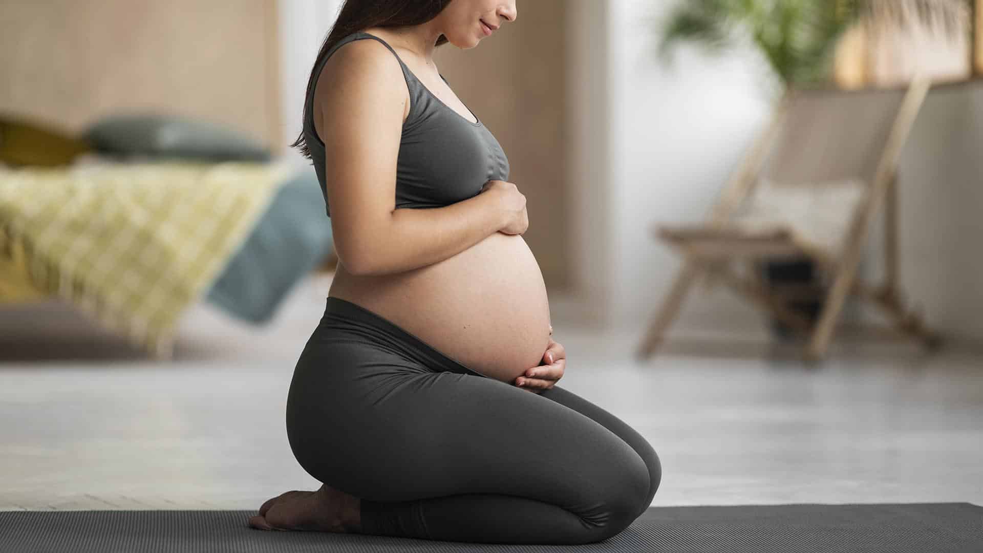 Mulher grávida sentindo a barriga dura