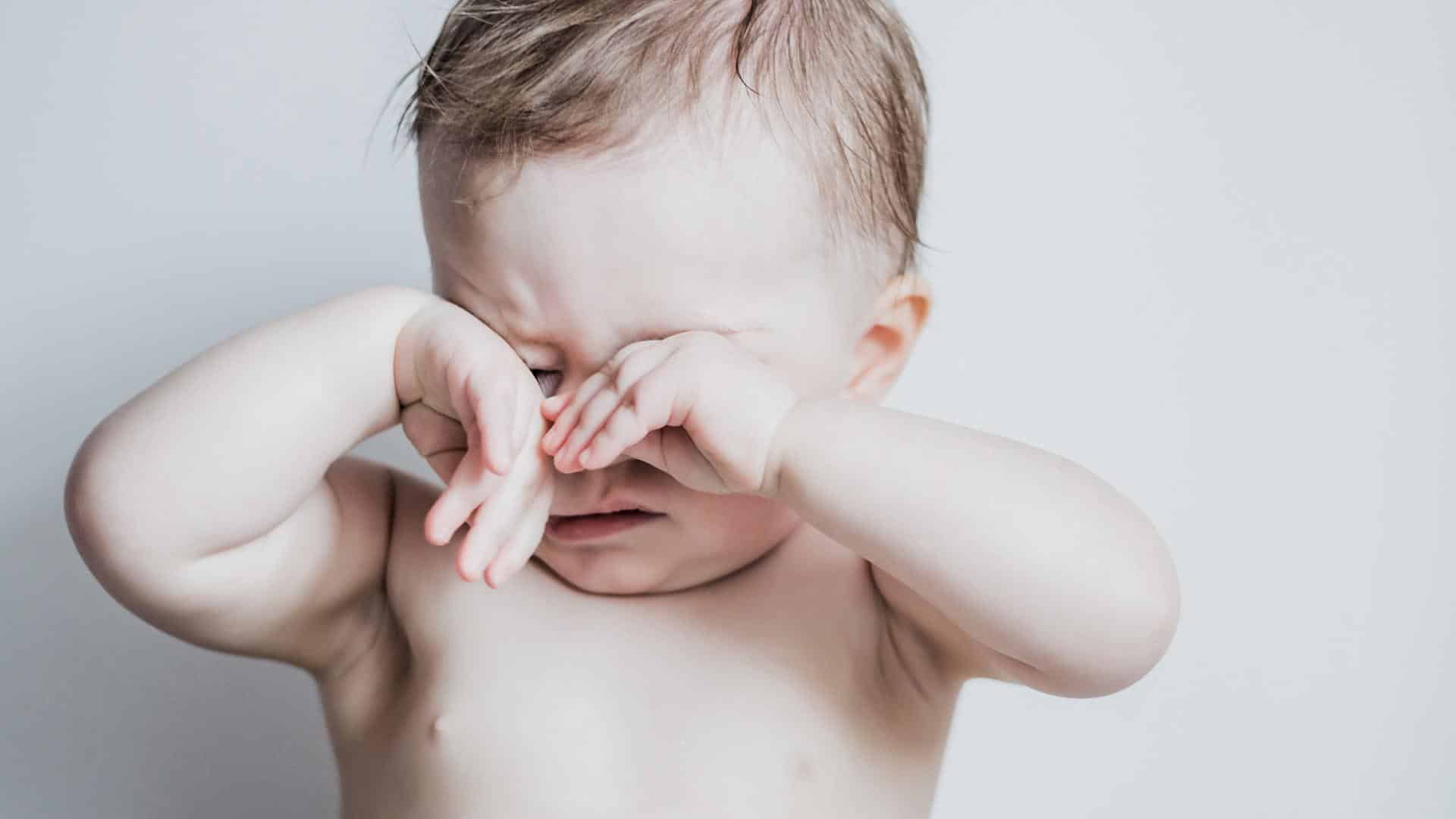 Bebê esfregando os olhos em sinal de cansaço