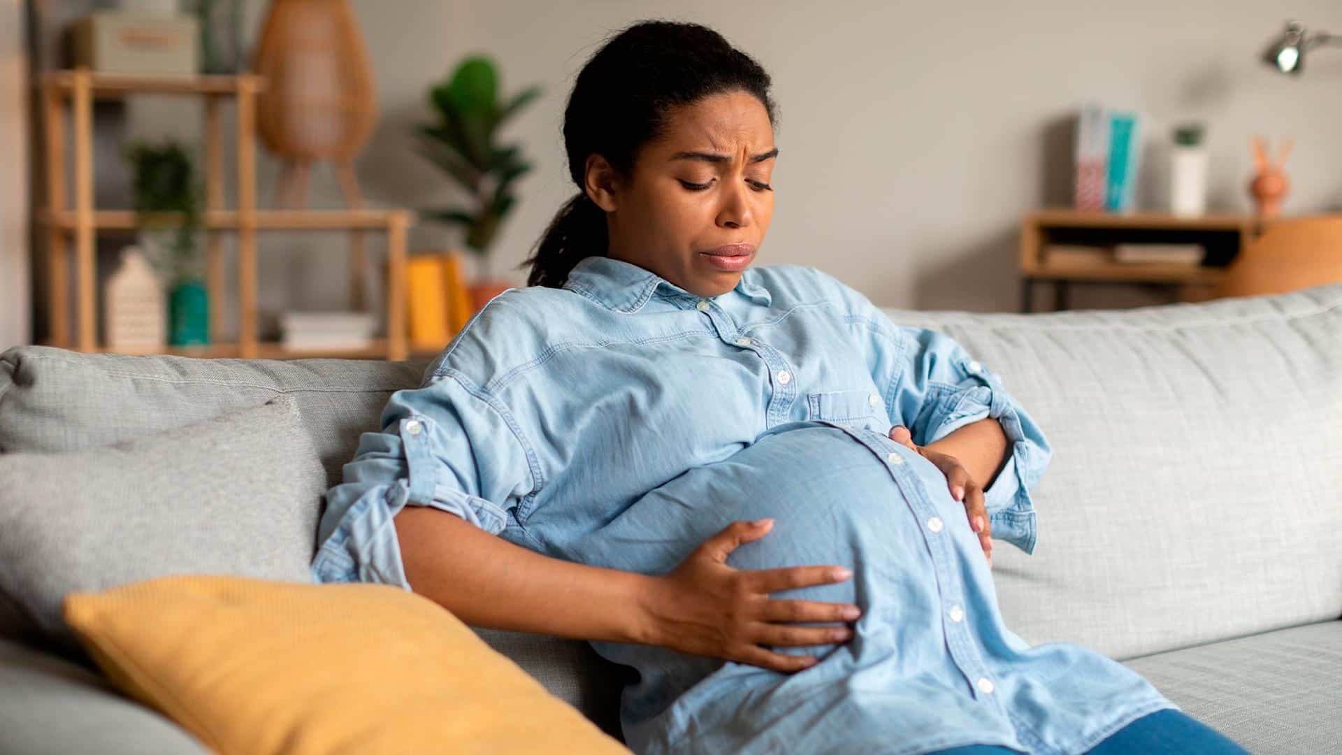 Gestante apalpando região da barriga