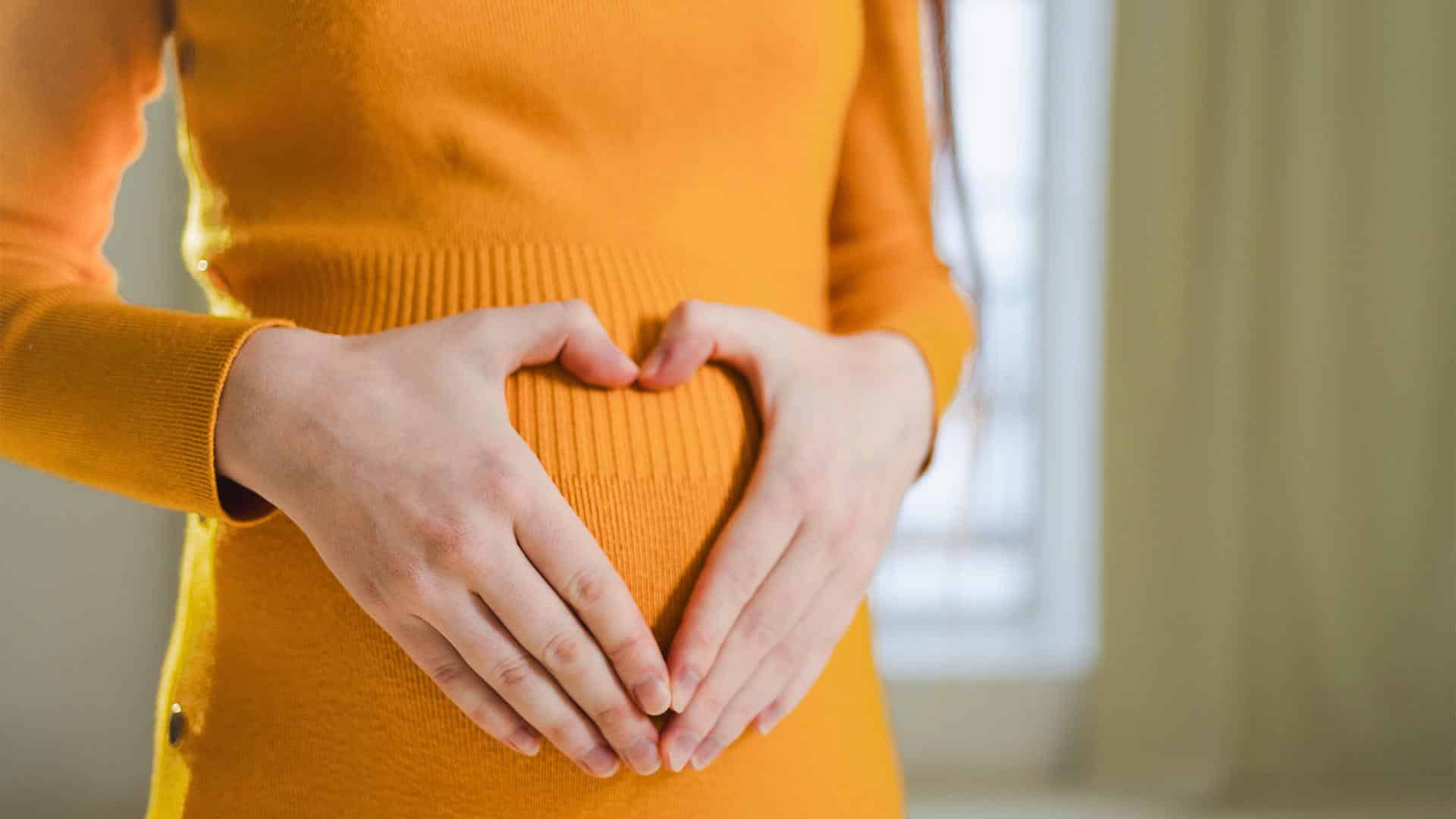 Gestante apalpando sua barriga com amor