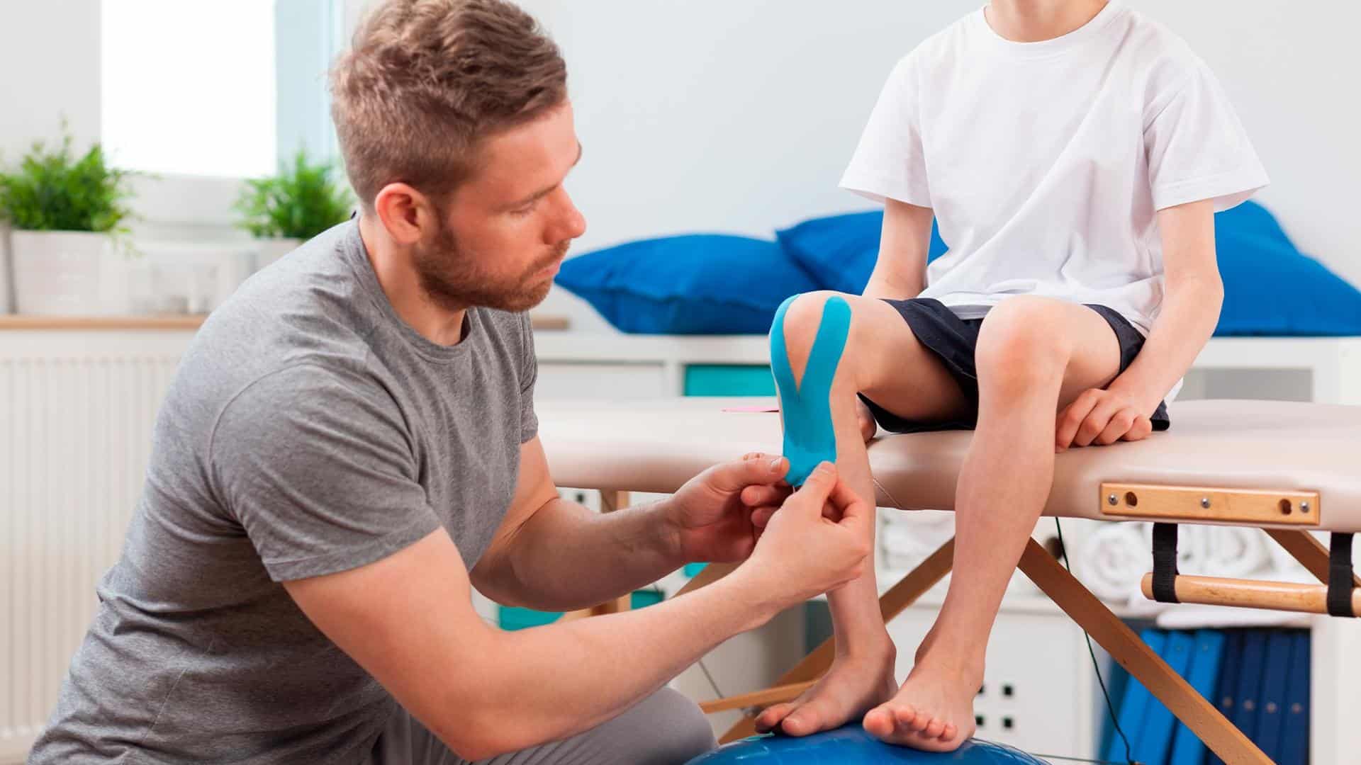 Pai examinando o joelho do filho