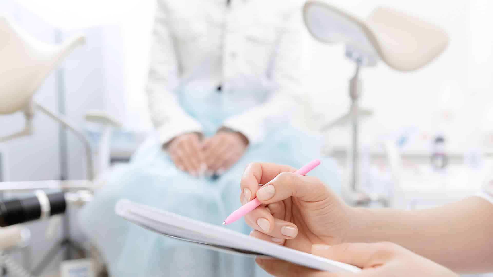 Médica anotando informações da gestante