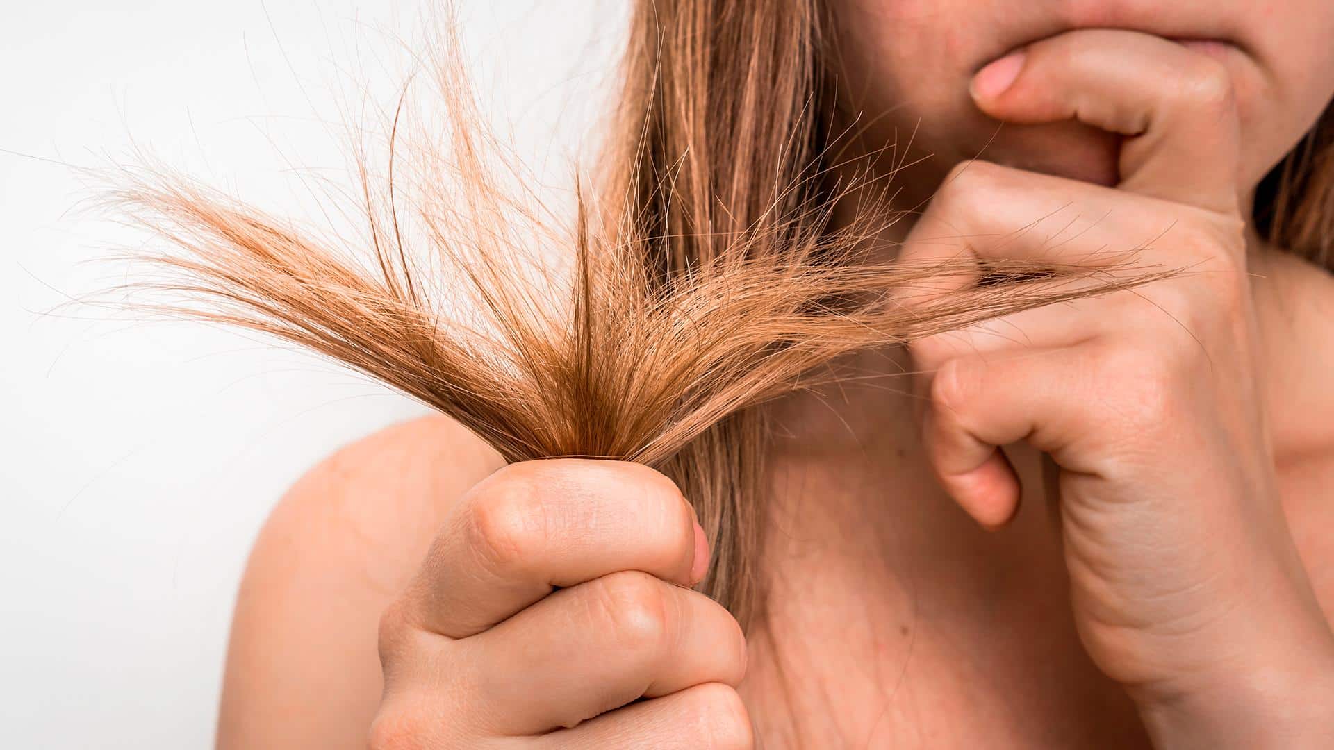 Mulher segurando pontas do cabelo